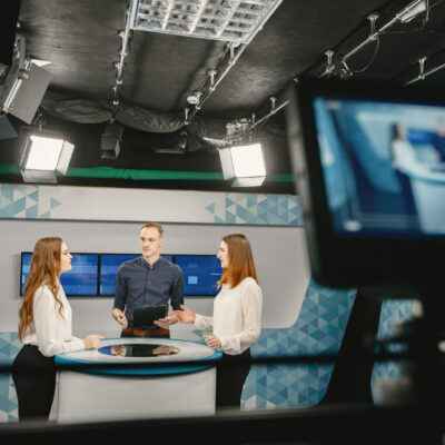 Camera filming tv show with host and two women